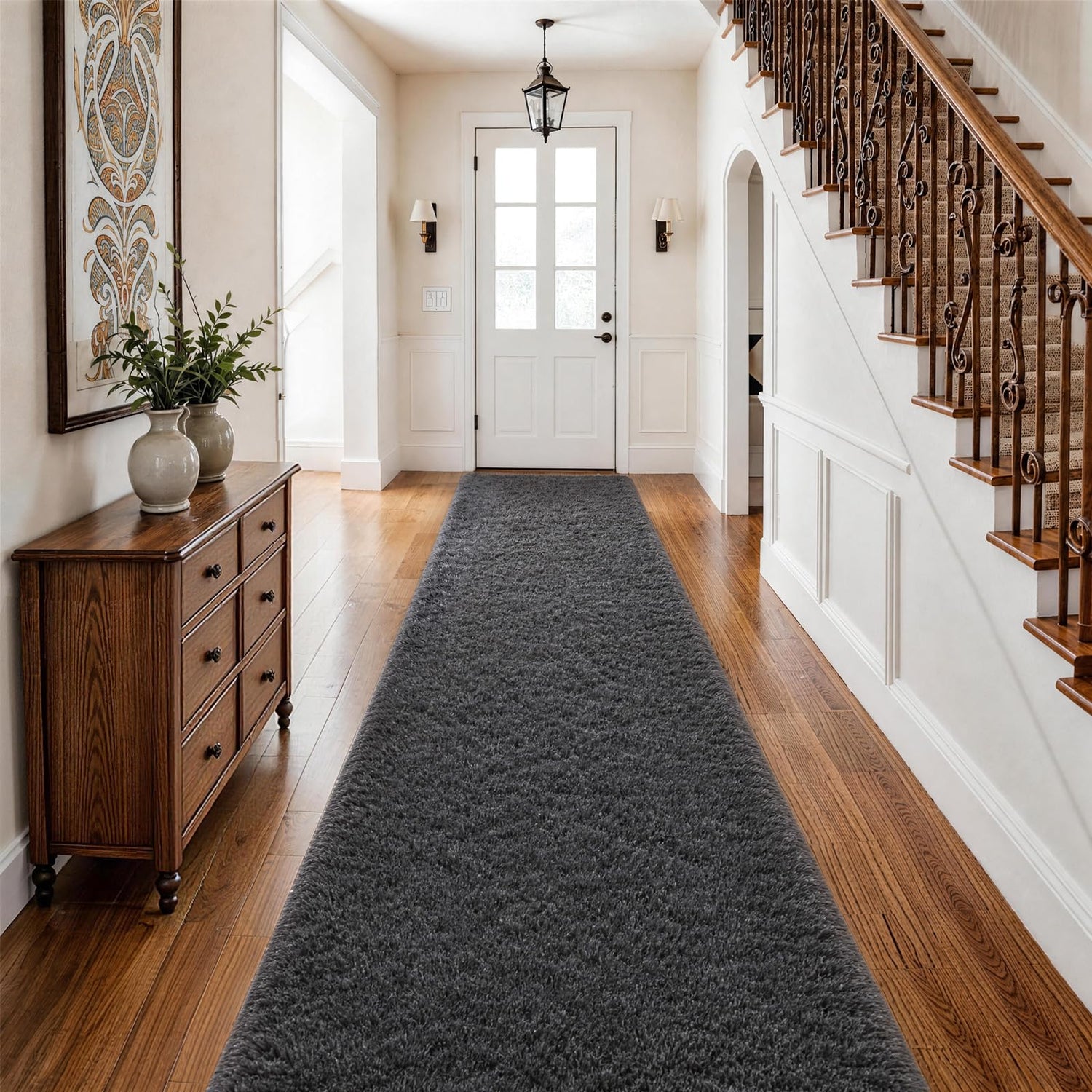 Dark gray fluffy runner centered in a foyer with staircase and wooden sideboard