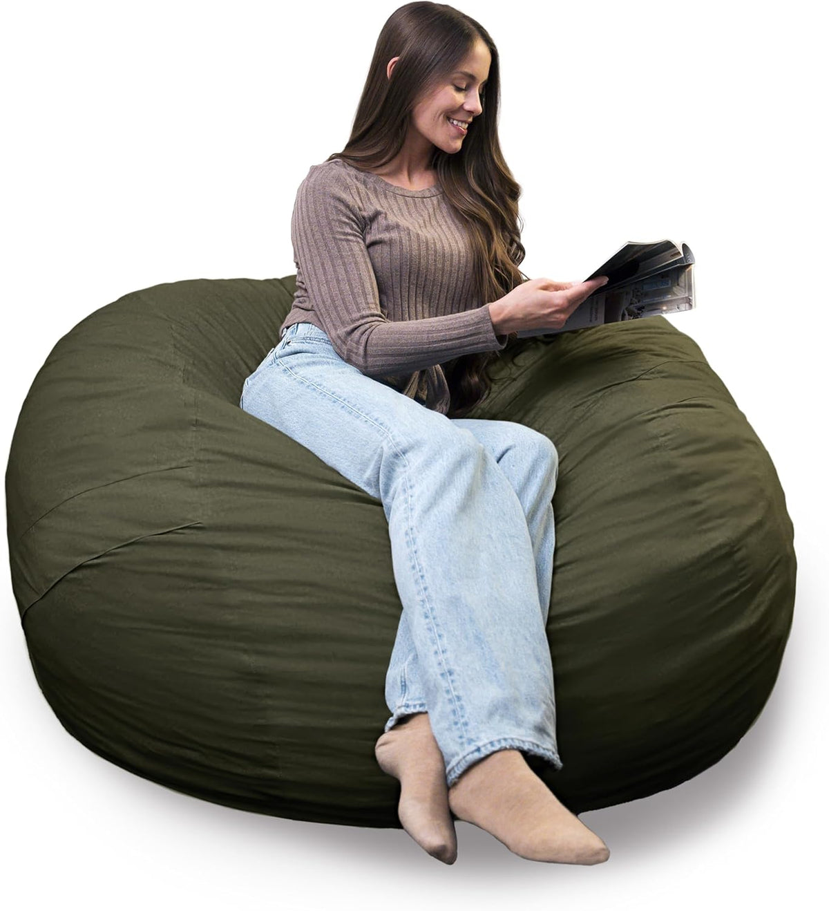 Woman reclining and reading on a large olive-green bean bag with her legs stretched toward the camera.