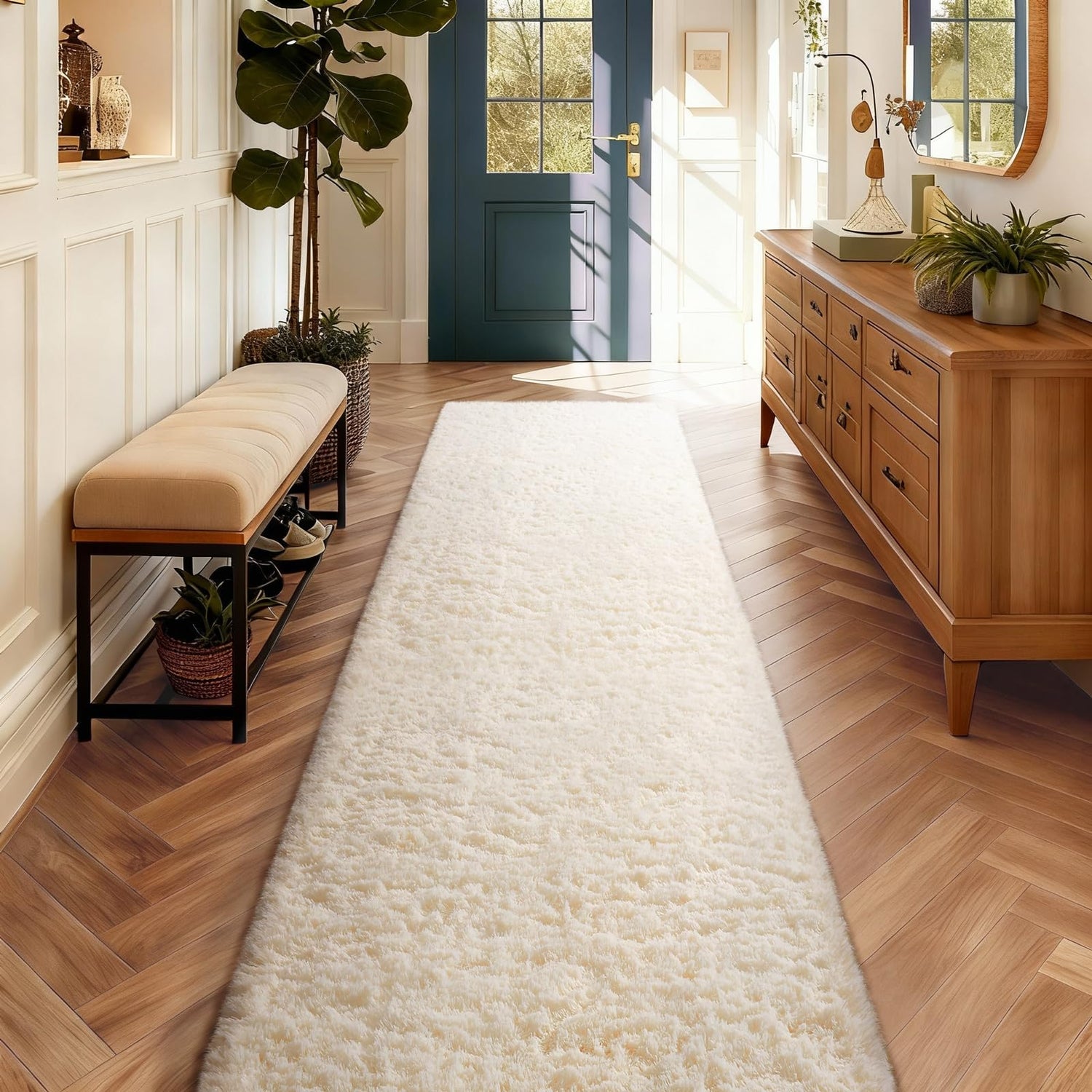 Hallway view with long cream shag runner leading to teal front door, upholstered bench and wooden console.