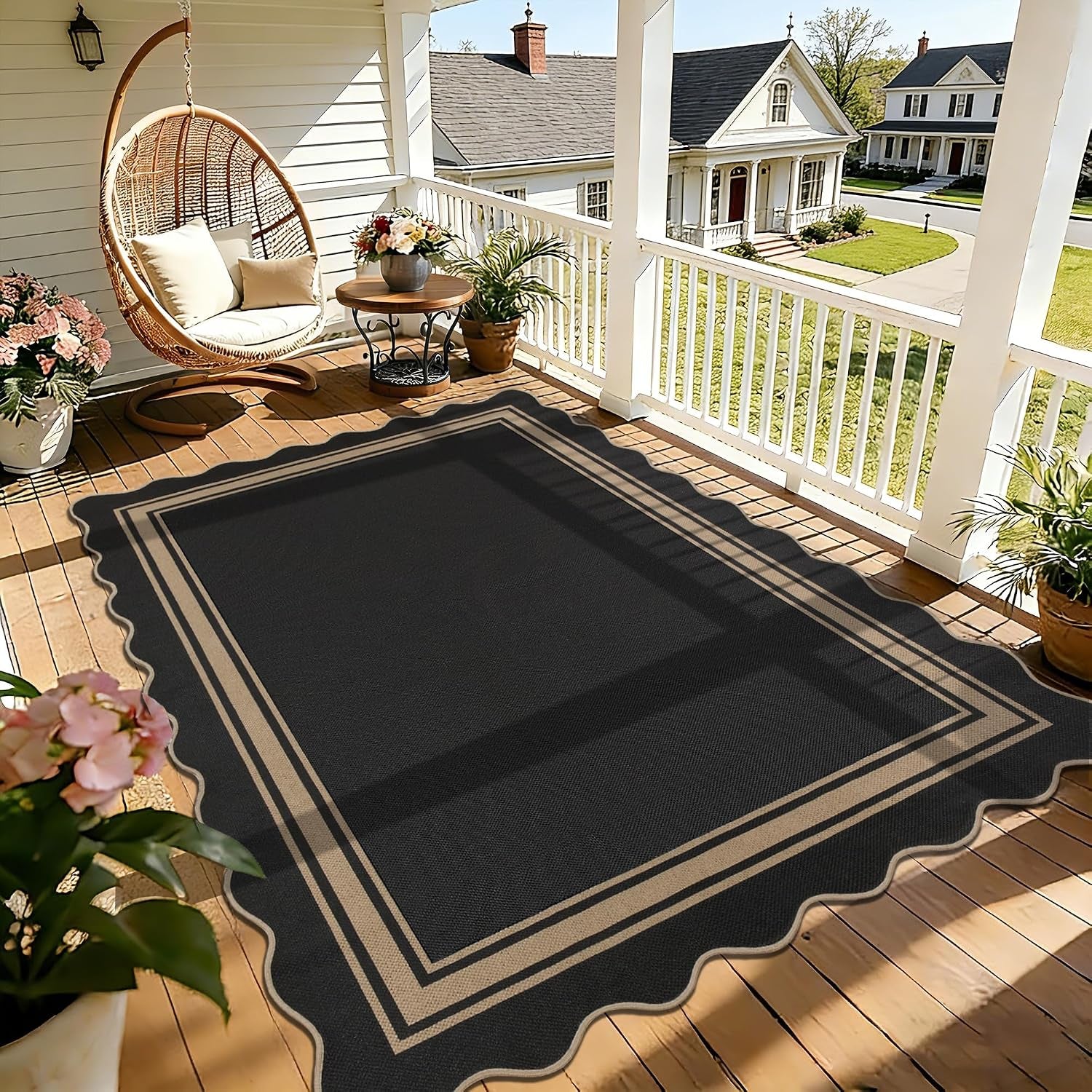 Black scalloped-edge rug with tan border placed on a sunlit wooden porch under a hanging chair.