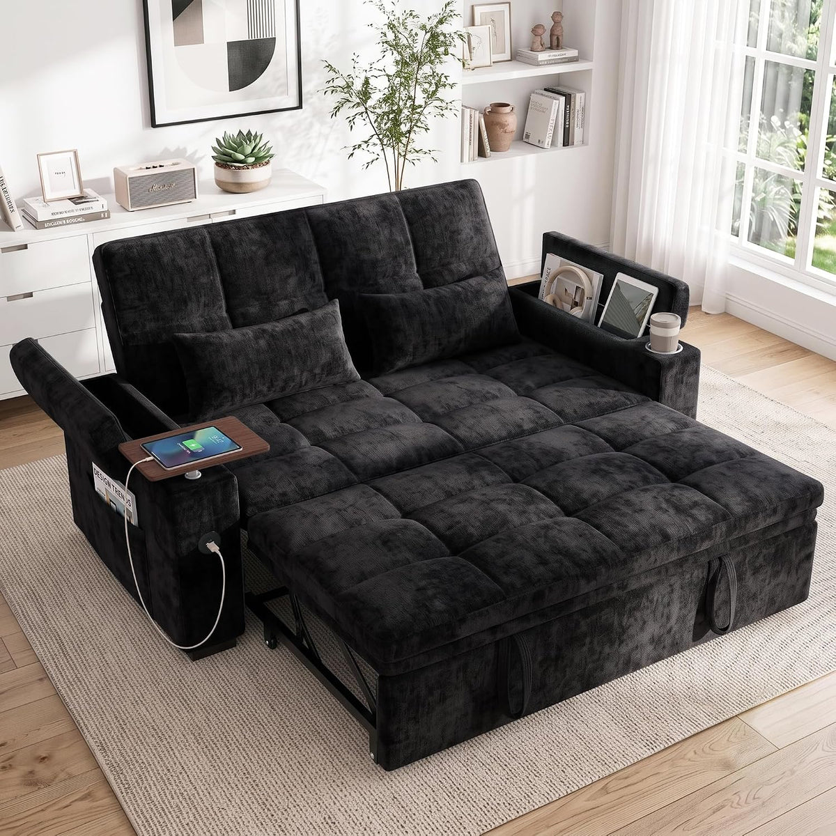 Three-quarter view of the charcoal sleeper sofa in a bright room showing armrest pockets, swivel table and cup holder.