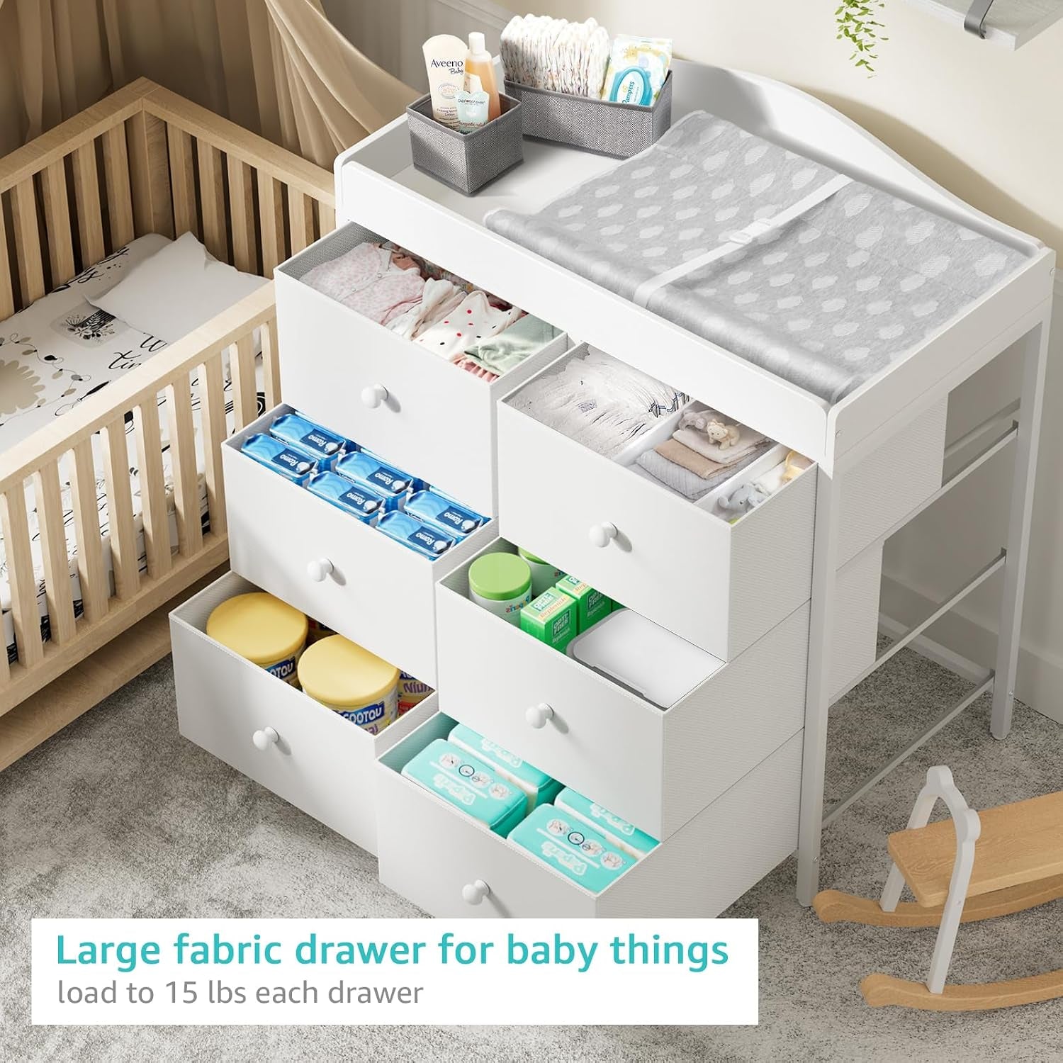 Bird's-eye view of the white changing dresser with several drawers pulled out filled with diapers, wipes and clothing.