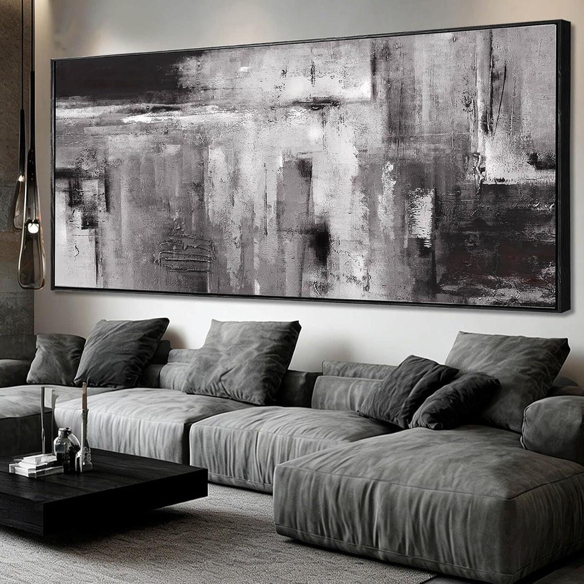 Wide framed abstract canvas mounted above a low gray modular sofa with plush cushions and a black coffee table
