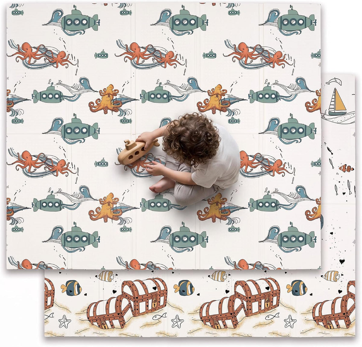 Bird's-eye view of a child playing on a cream mat patterned with green submarines and orange octopus, treasure-scene print