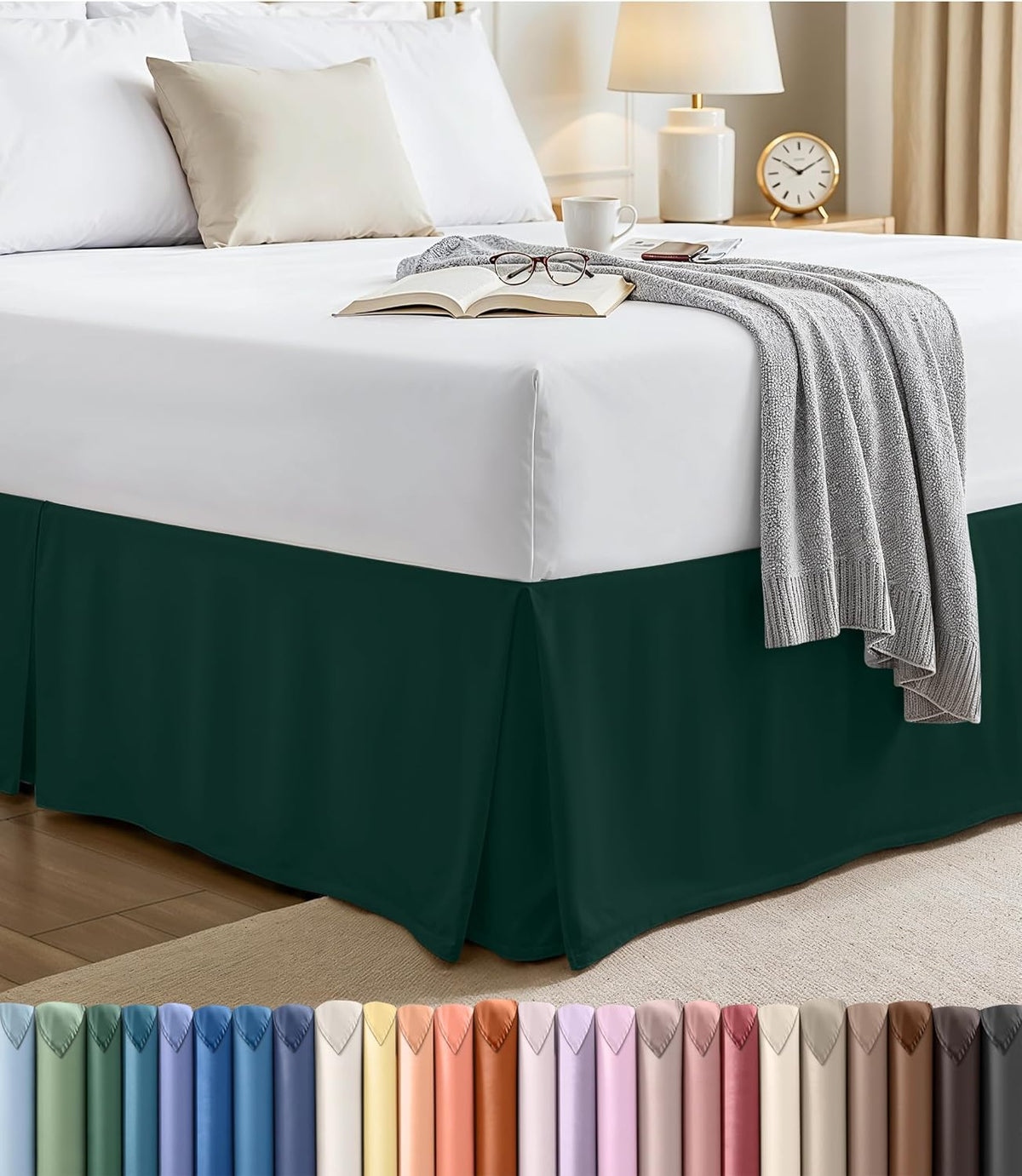 Corner view of a made bed with a dark green pleated bed skirt and white mattress