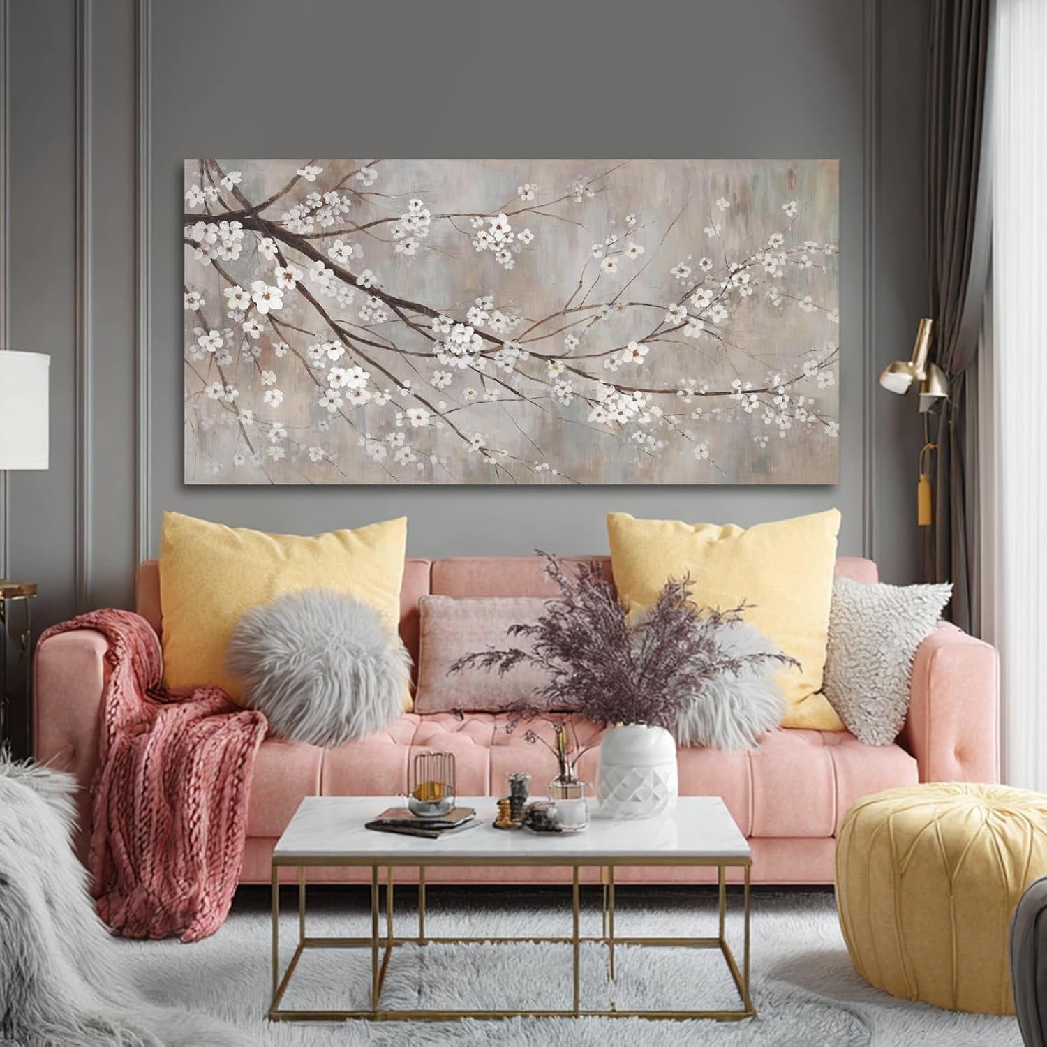Plum blossom canvas over a pink sofa with yellow pillows in a living room, frontal view