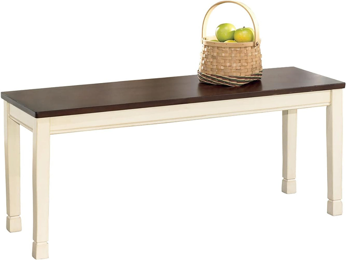 Two-tone backless dining bench with burnished brown top and cottage white painted frame, front angled view with basket on top
