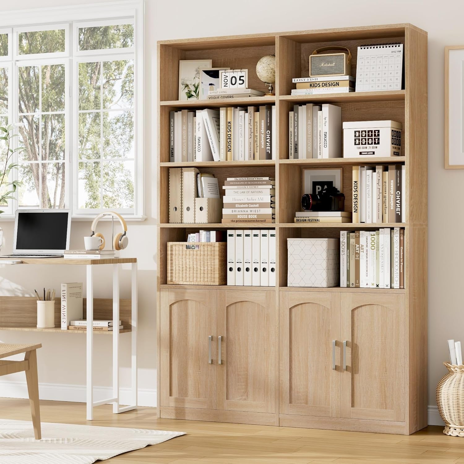 Oak-finish bookshelf placed beside a desk in a bright home office, showing open shelves stocked with books