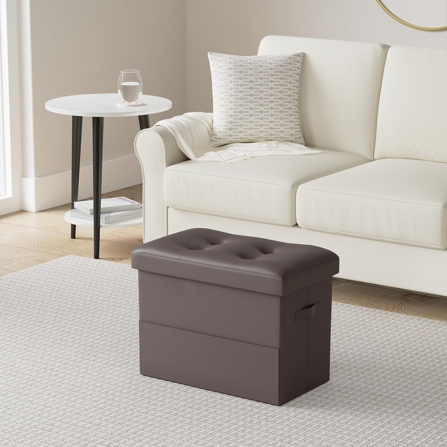 Brown PU leather ottoman placed in front of a white sofa in a living room setting