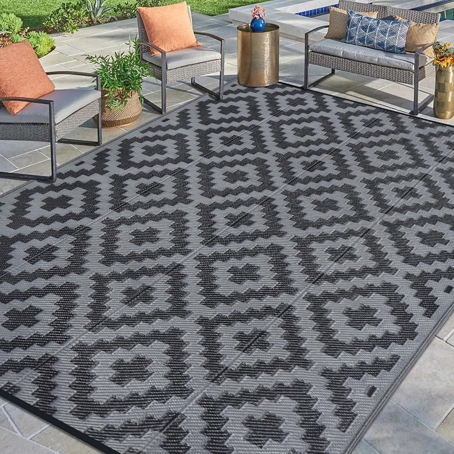 Poolside stone patio with gray rug featuring darker gray geometric motifs
