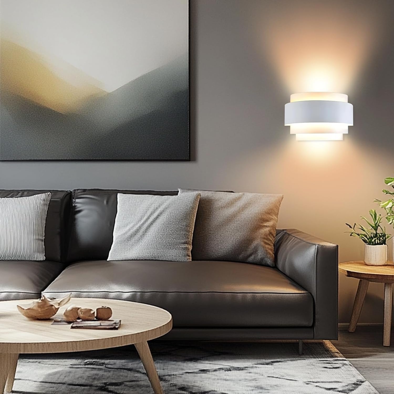 Small white layered wall sconce lit above a sofa in a modern living room vignette.