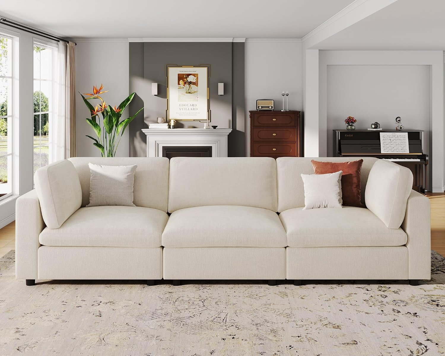 Straight-on view of the three-seat section of the cream sofa with two throw pillows against a living room backdrop.