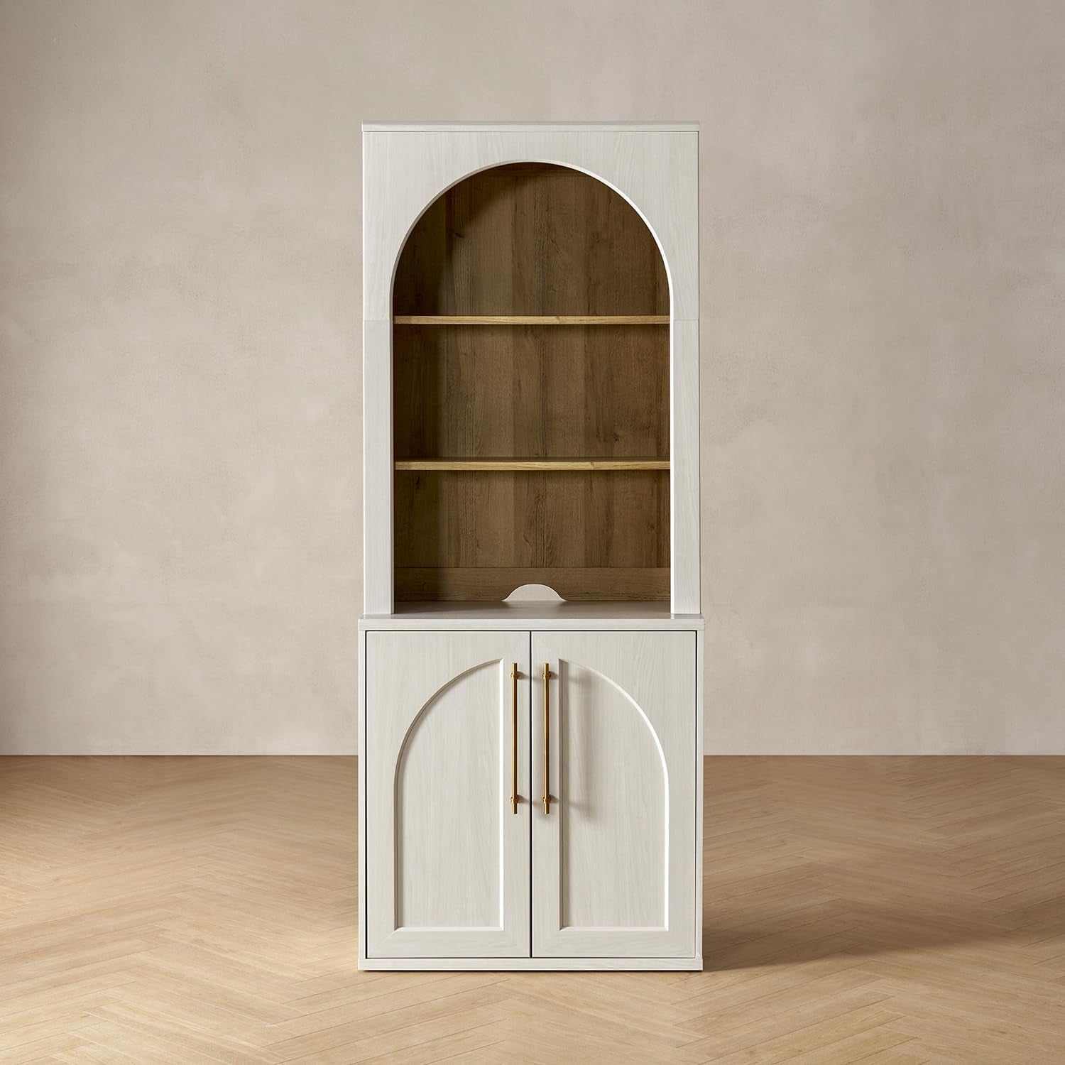 Tall white hutch with arched open shelving above and closed lower cabinet with arched door panels and brass handles.
