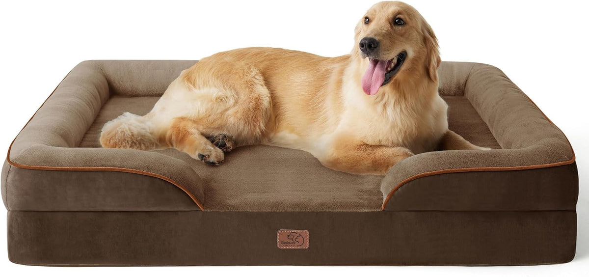 Golden retriever lying with tongue out on a brown rectangular bolster dog bed.