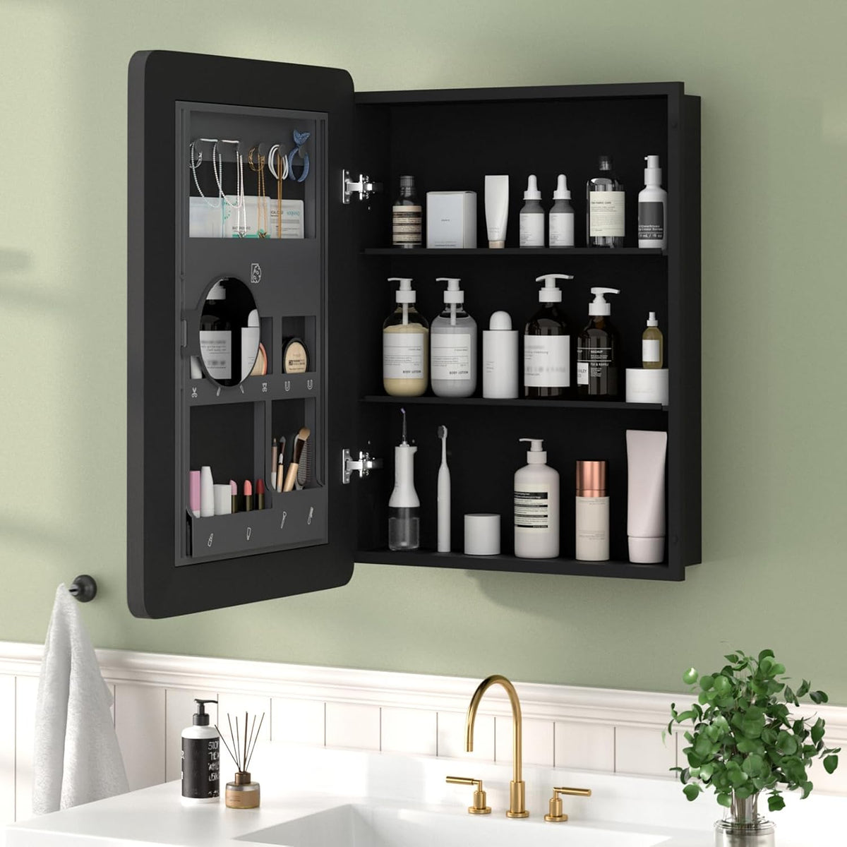 Open black medicine cabinet mounted on green wall showing interior shelves and door organizer.