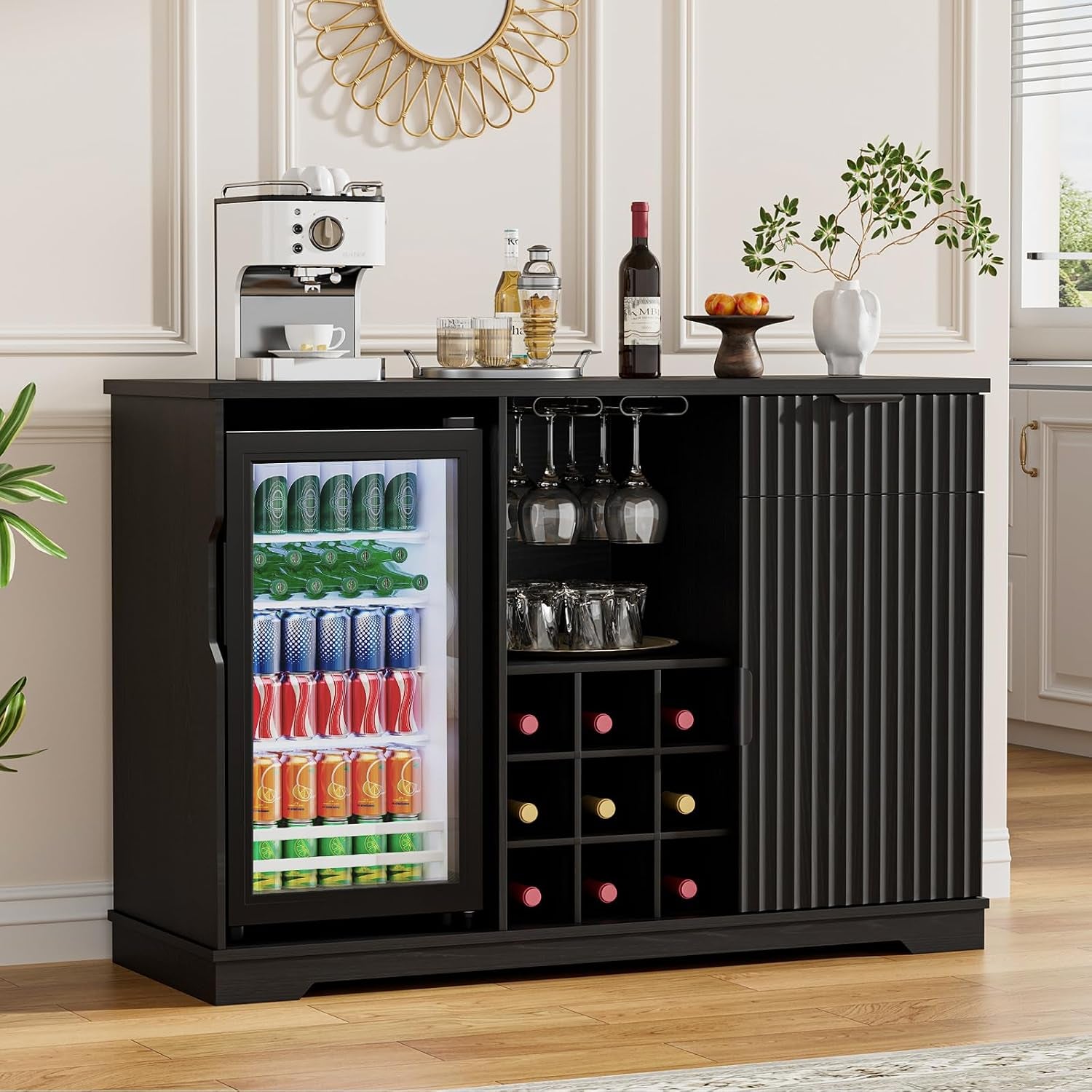 Black fluted bar cabinet front view with glass-front mini fridge filled with cans, central wine grid and items on the top