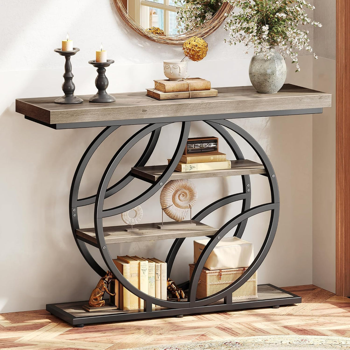Full front view of the console in a dark metal finish with gray wood shelves styled with books and decor.