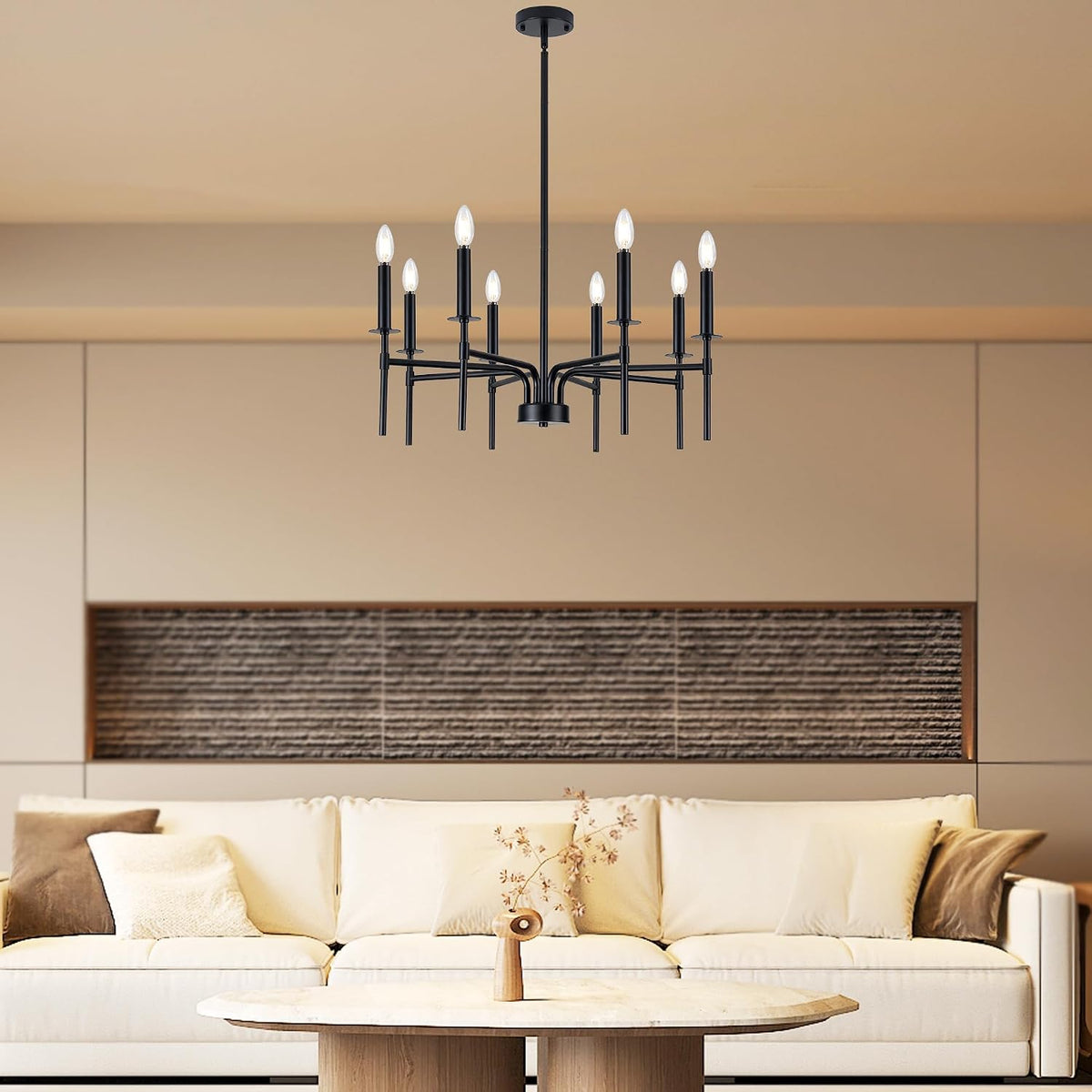 Black 8-light chandelier suspended over a living room sofa, wide-angle view showing the fixture in room context.