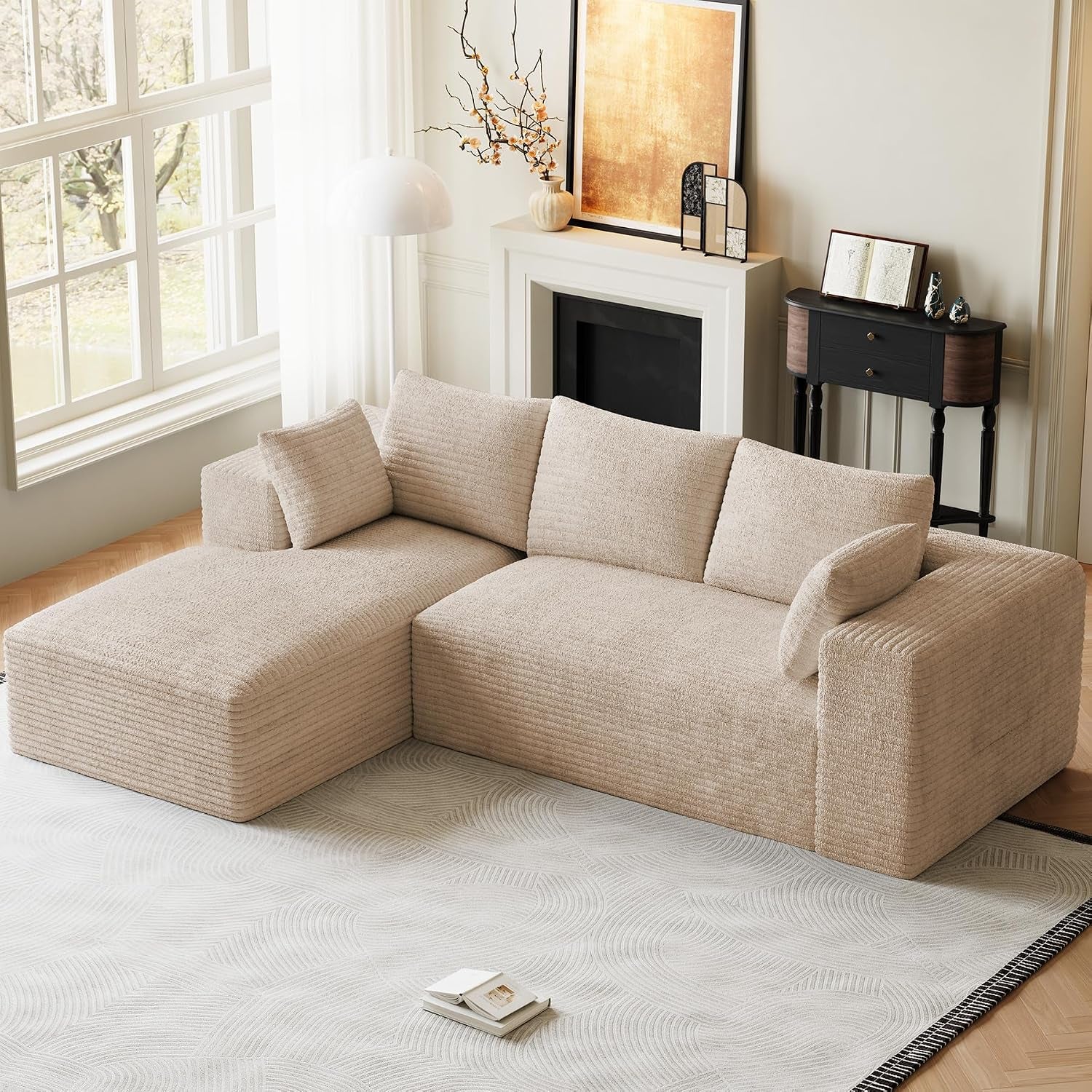 Beige L-shaped modular sectional with chaise staged by a fireplace and large window