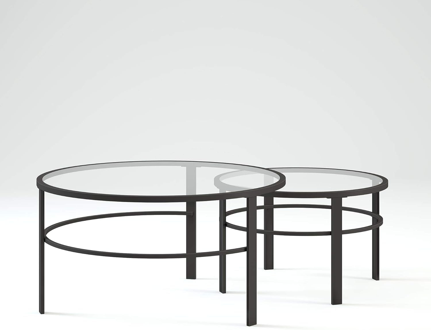 Front three-quarter studio view of the nested round glass tables, one partially tucked under the other on a white backdrop.
