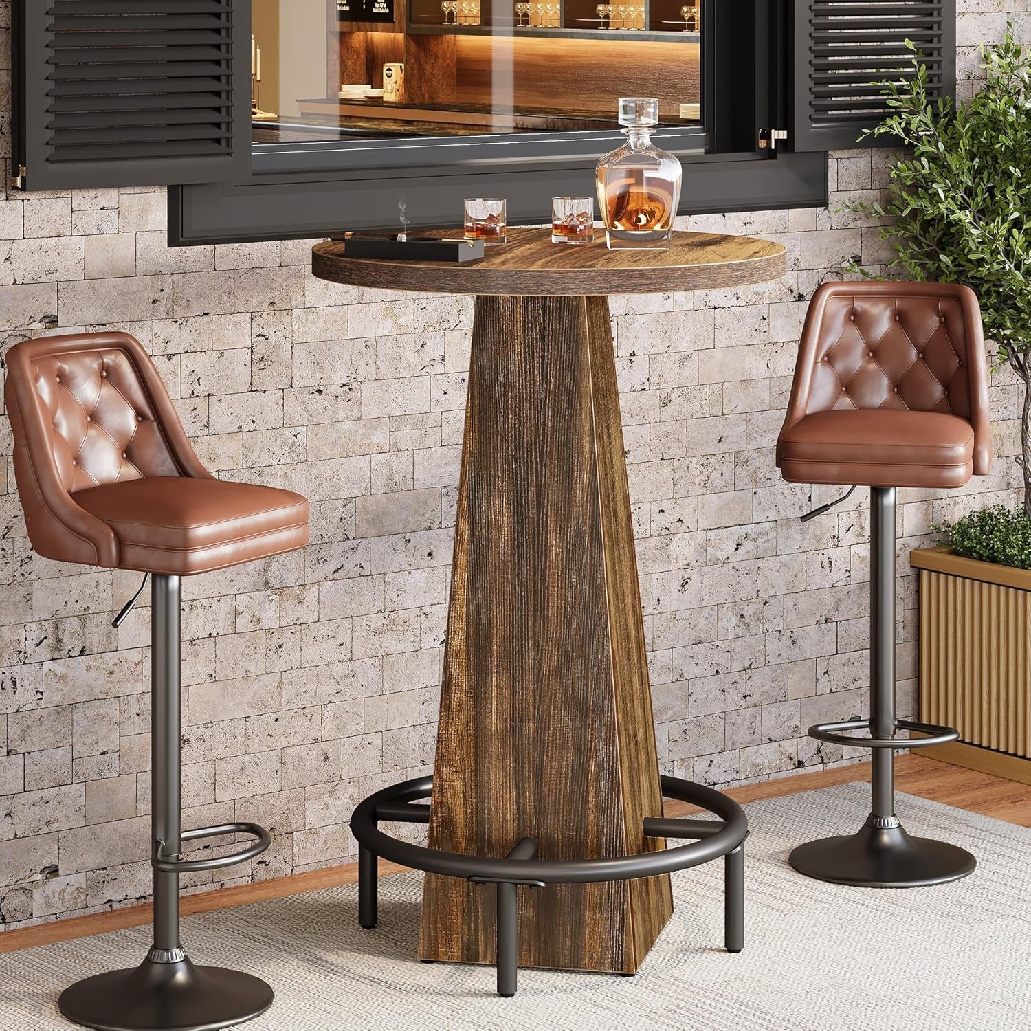 Round counter-height table in rustic brown with black metal circular footrest, flanked by two leather-upholstered bar stools