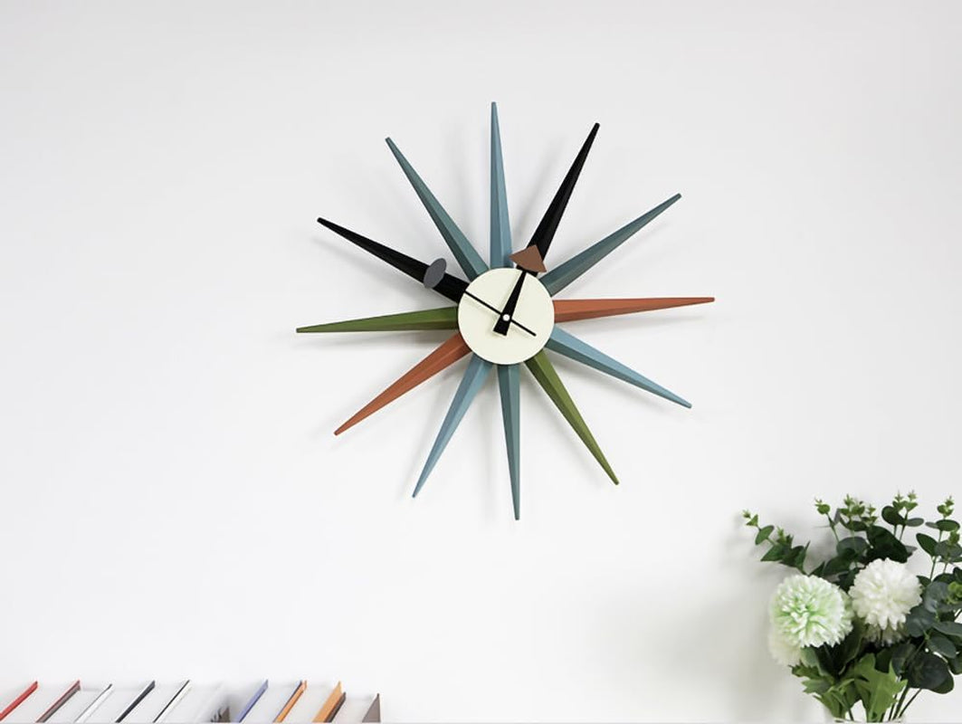 Front view of the clock on a white wall with books at lower left and flowers at lower right for scale.