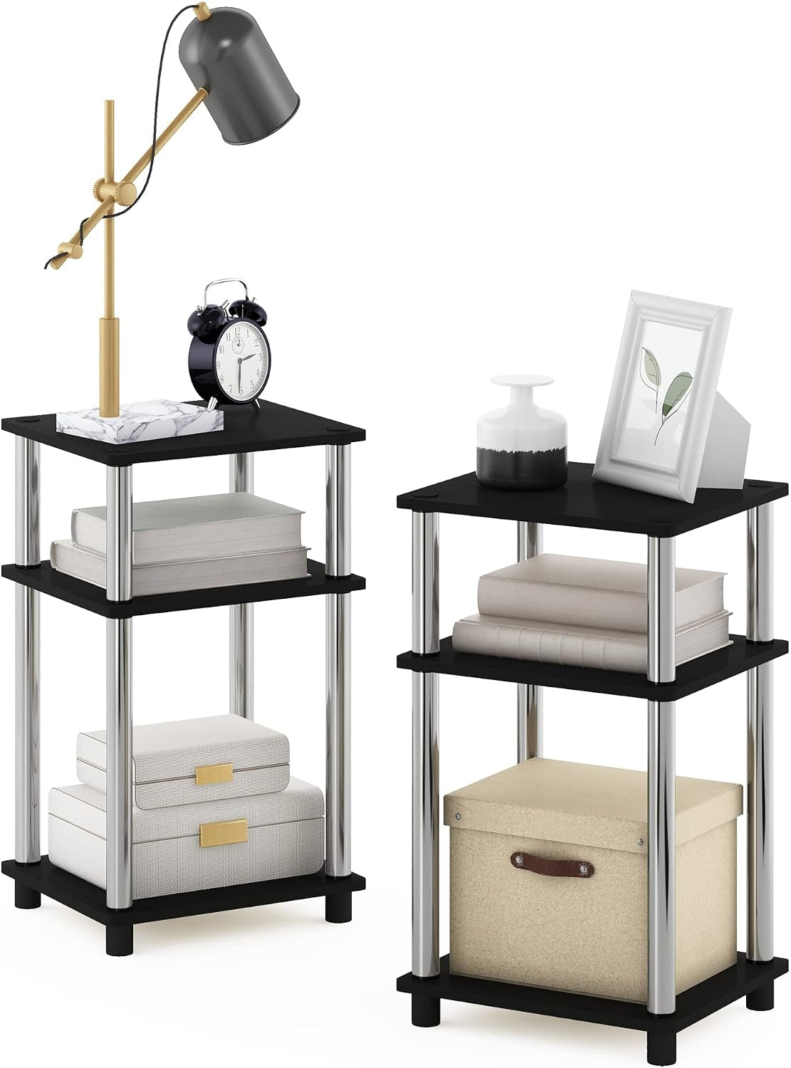 Pair of three-tier tables with black shelves and shiny silver cylindrical posts holding decorative items