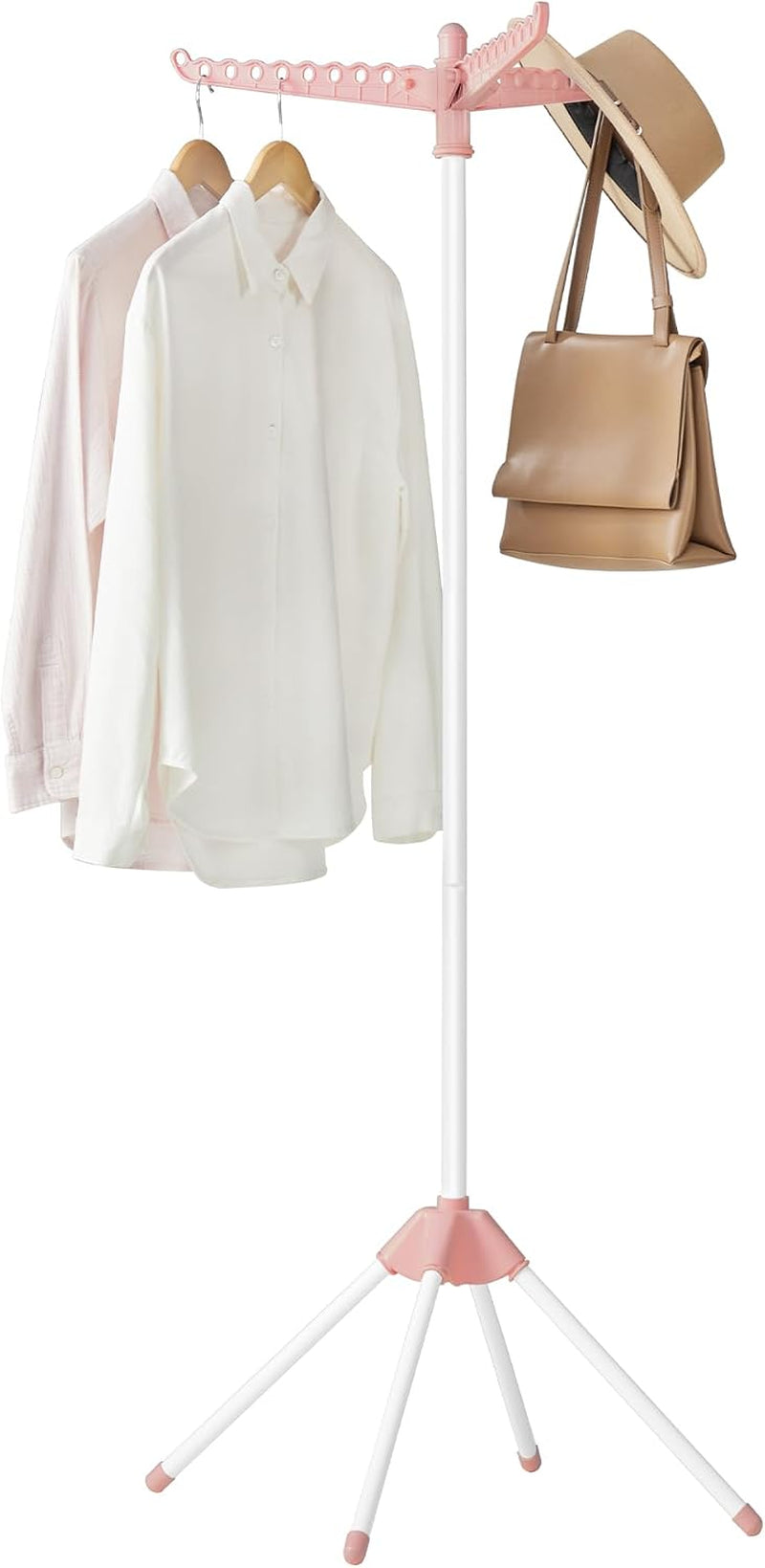 Pink-and-white freestanding clothes drying rack with three rotating arms holding shirts, a hat, and a bag.