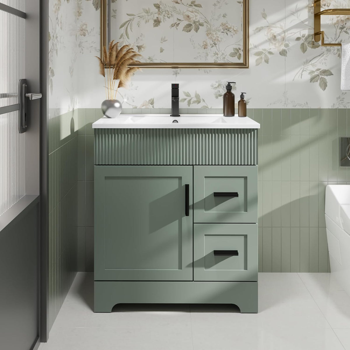 Angled close front of the green vanity showing cabinet doors and two stacked drawers with black pulls.