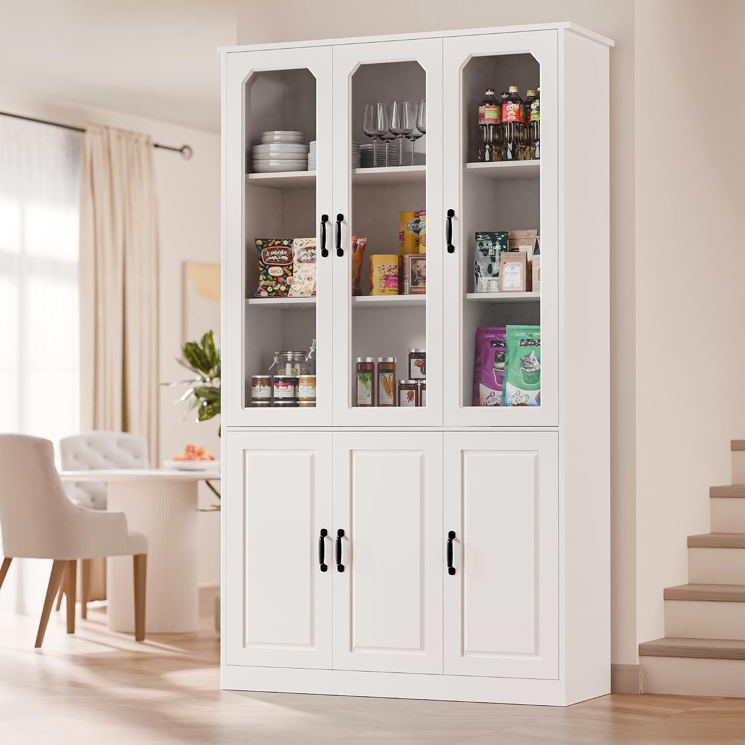 White tall pantry cabinet with three glass doors and lower closed doors, front-left angled view in a dining area