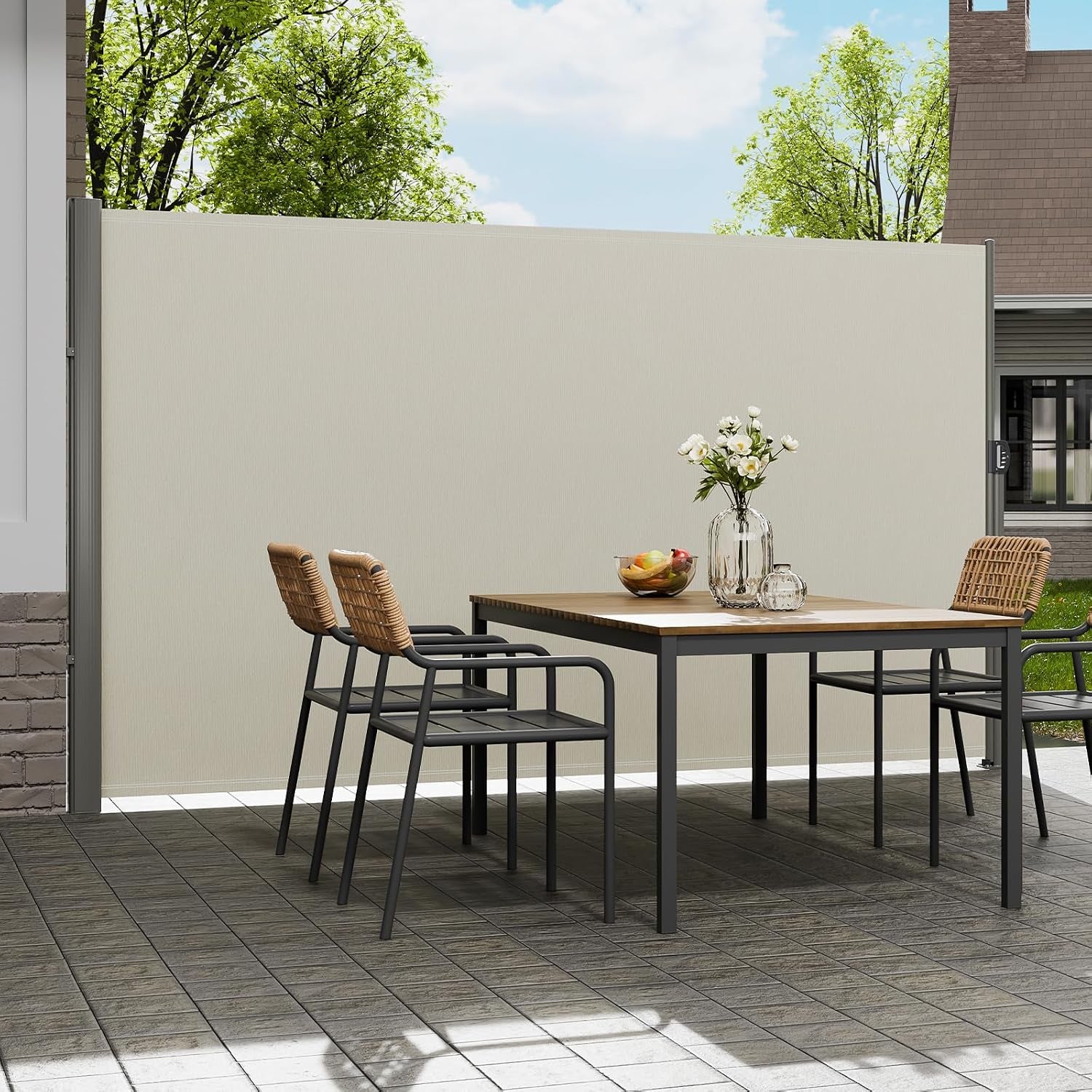 Patio dining area seen at an angle with a beige retractable side screen pulled down behind a table and four chairs.