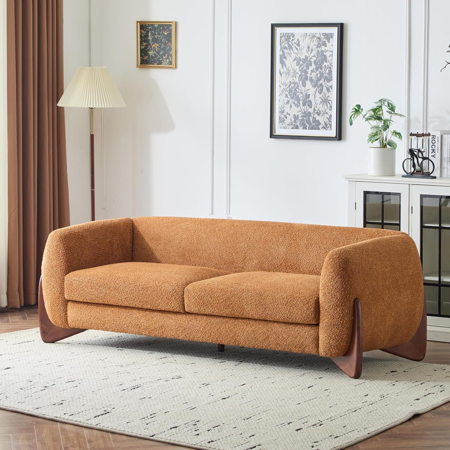 Caramel three-seat sofa angled front-right view on a rug with tapered birch legs visible