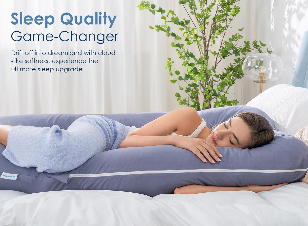 Woman side-lying on a blue U-shaped body pillow on a bed, profile view highlighting head and torso support