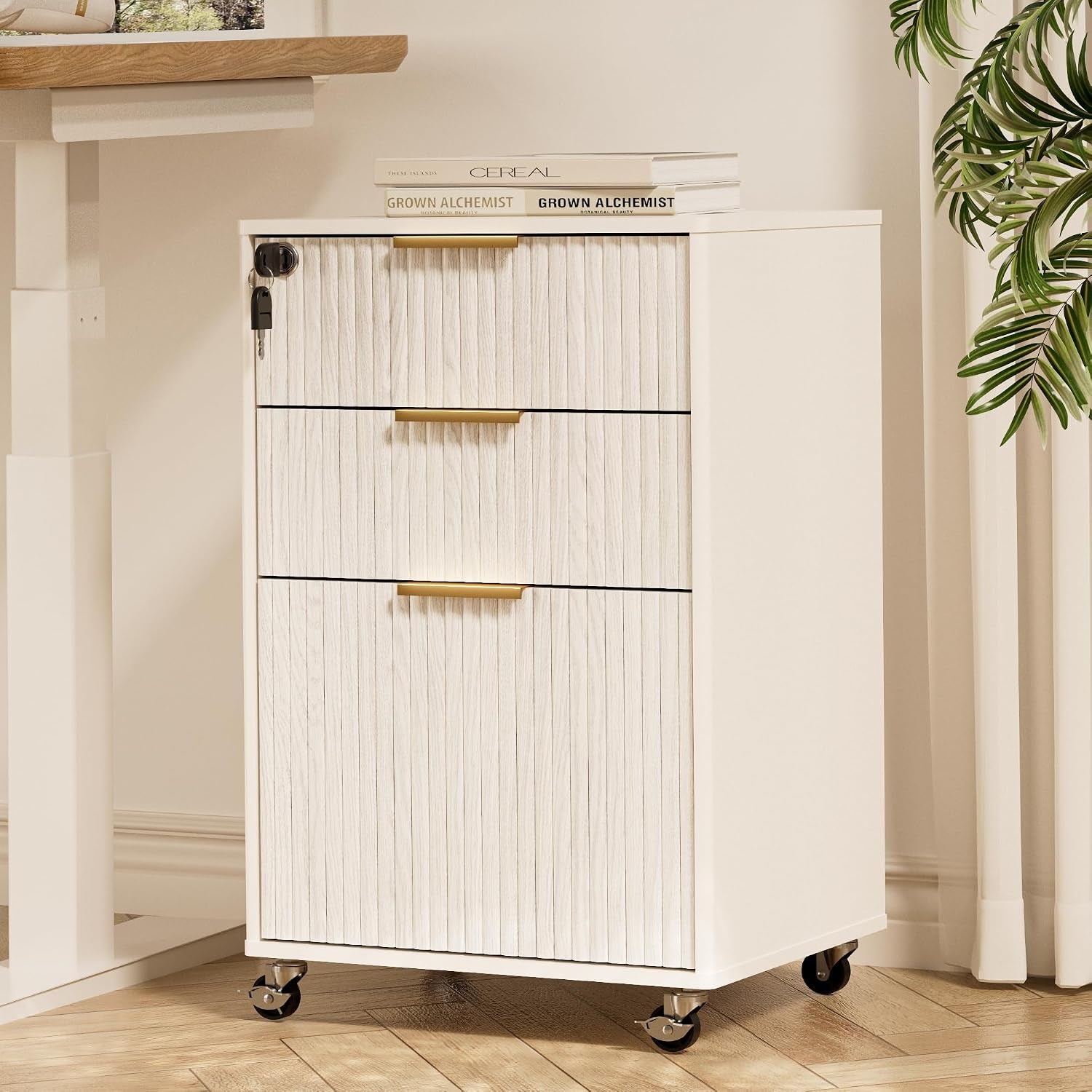Three-drawer mobile cabinet with white ribbed fronts, gold handles and a key lock on the top drawer