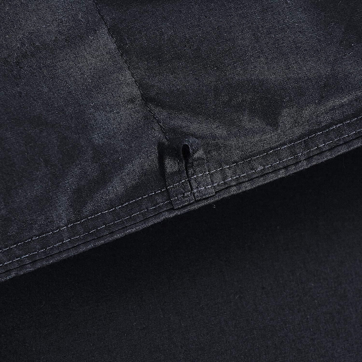 Close-up showing a stitched seam and a small fabric tie loop on the comforter edge.
