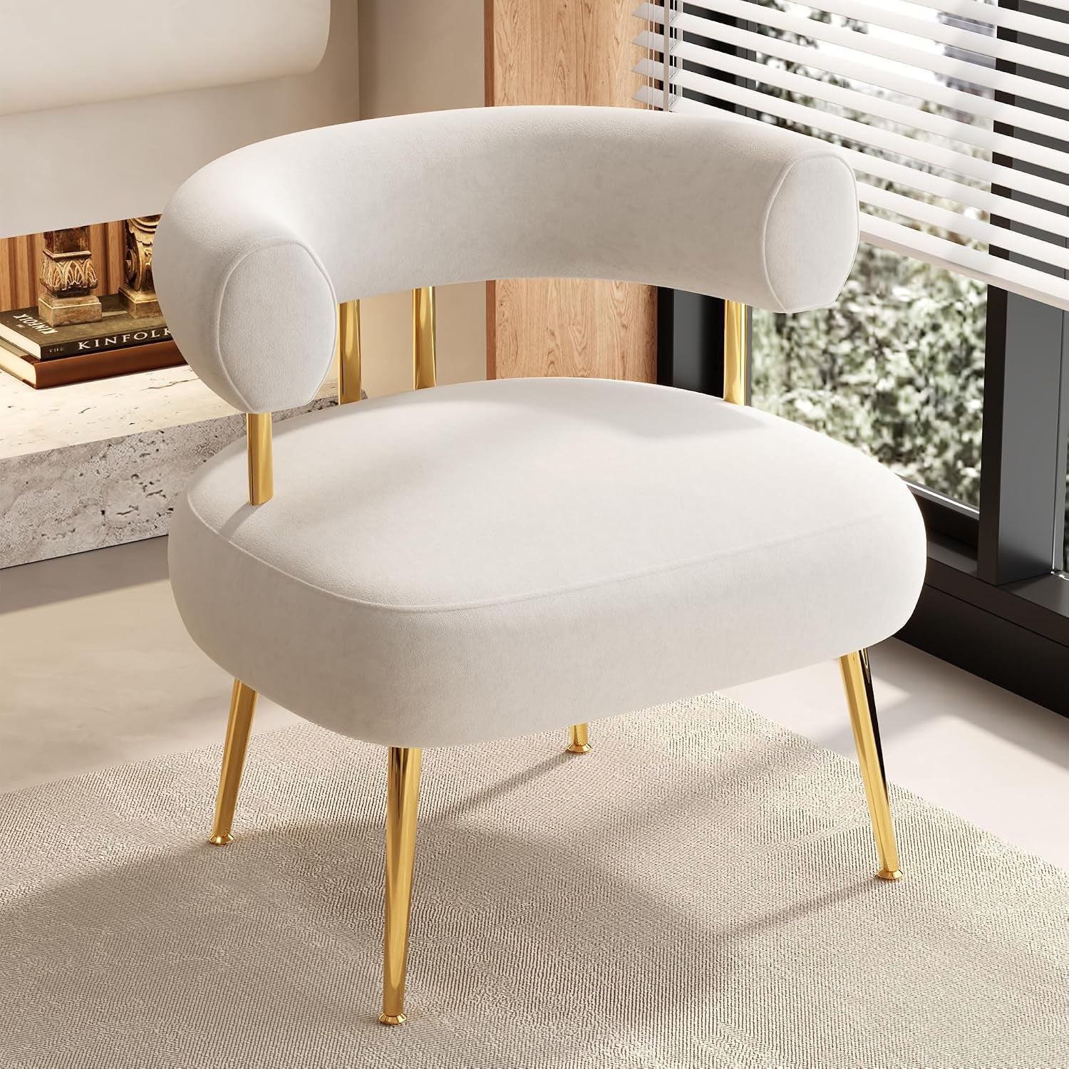 Cream rounded barrel accent chair with gold legs beside a window and textured rug