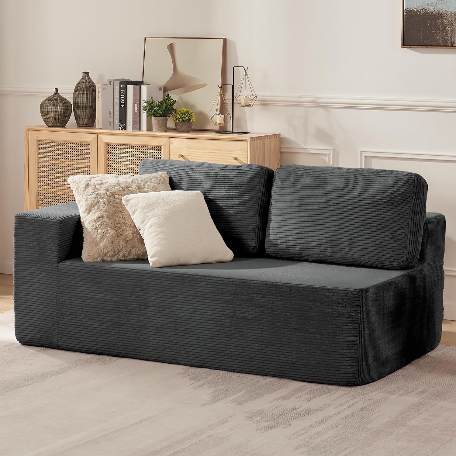 Three-quarter side view of a two-seat charcoal modular sofa module with two loose back cushions and decorative pillows.