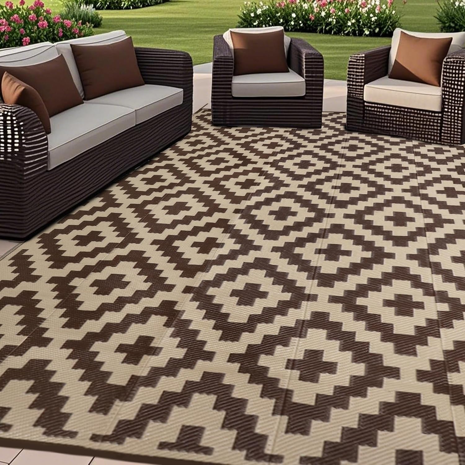 Outdoor seating area with a beige rug patterned in warm brown geometric diamonds under cushions