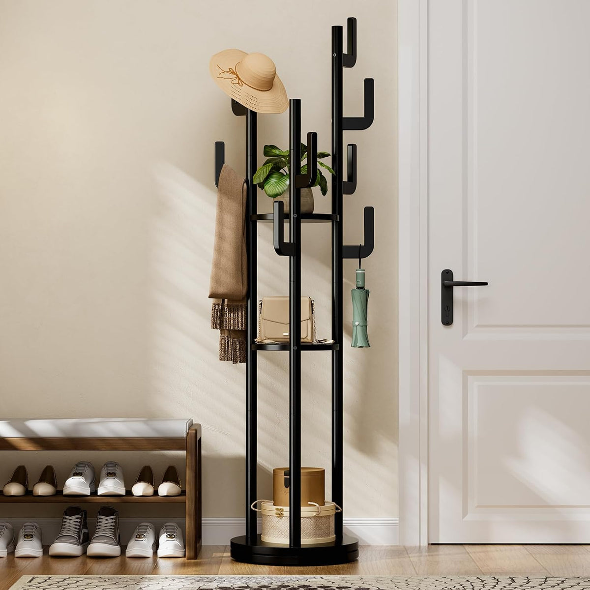 Black-finish coat rack in an entryway beside a shoe bench and white door, holding hat, scarf and umbrella