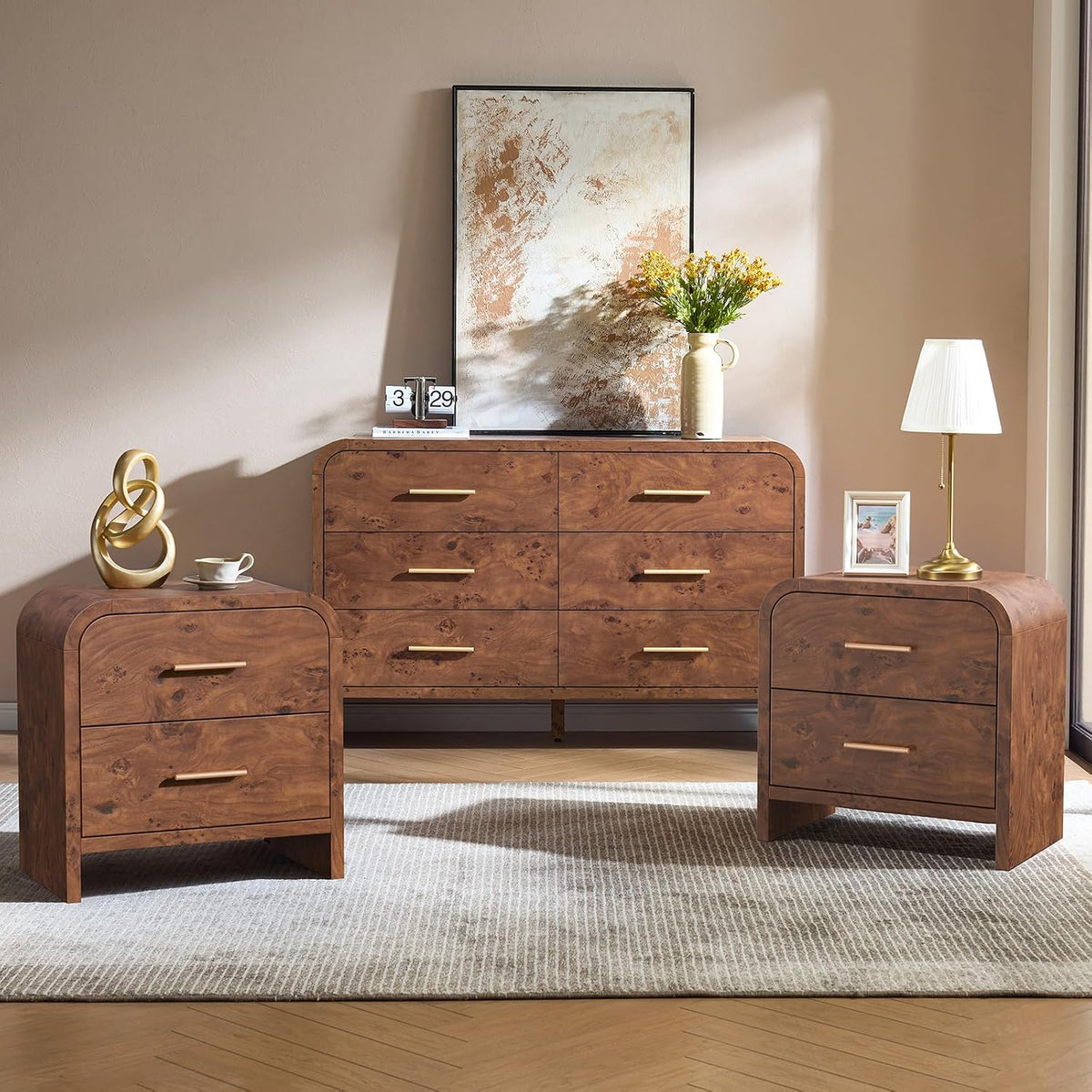 Warm brown 6-drawer dresser and two matching nightstands with gold handles on a herringbone floor.