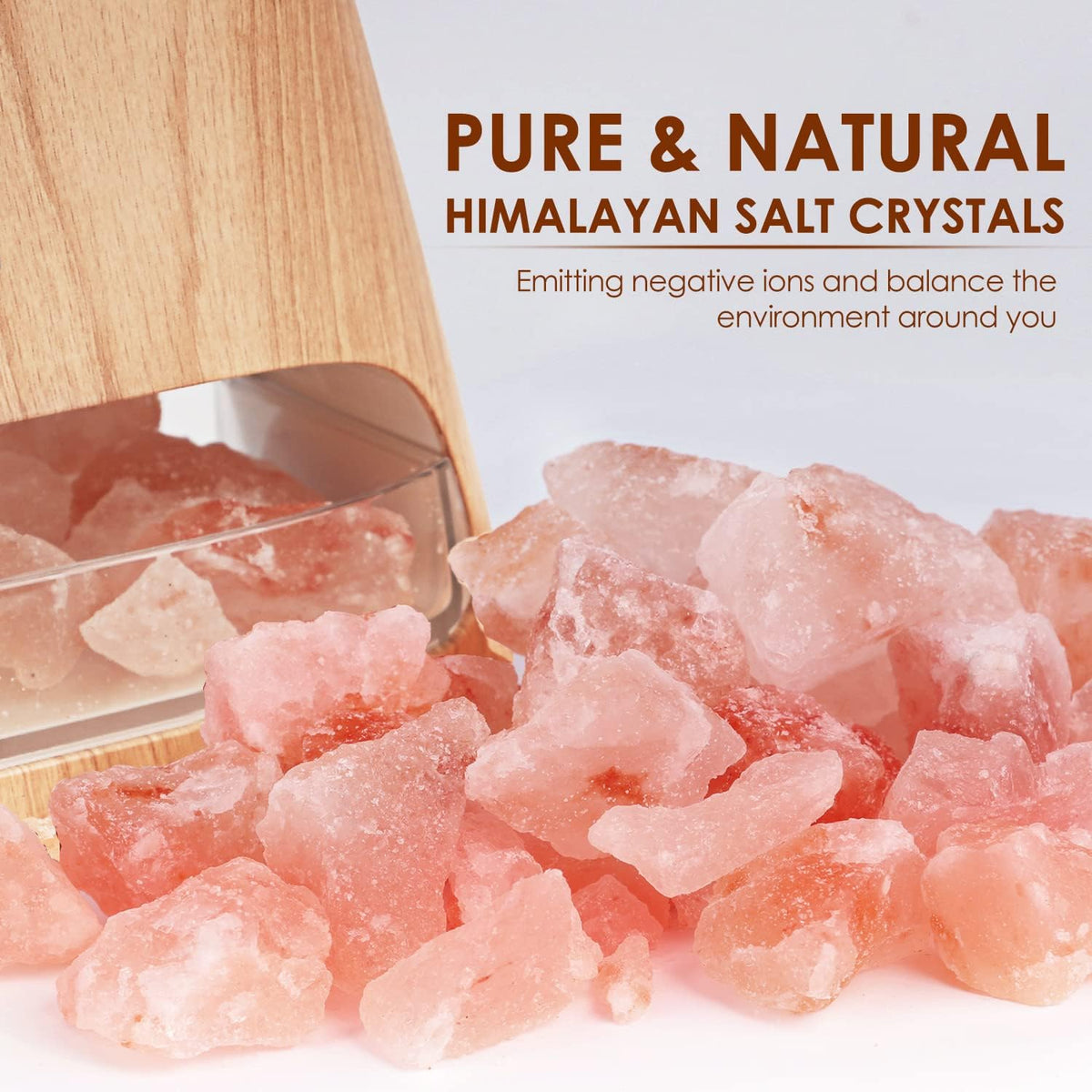Close-up pile of pink Himalayan salt crystals with the diffuser's clear salt tray and wood-grain body visible behind
