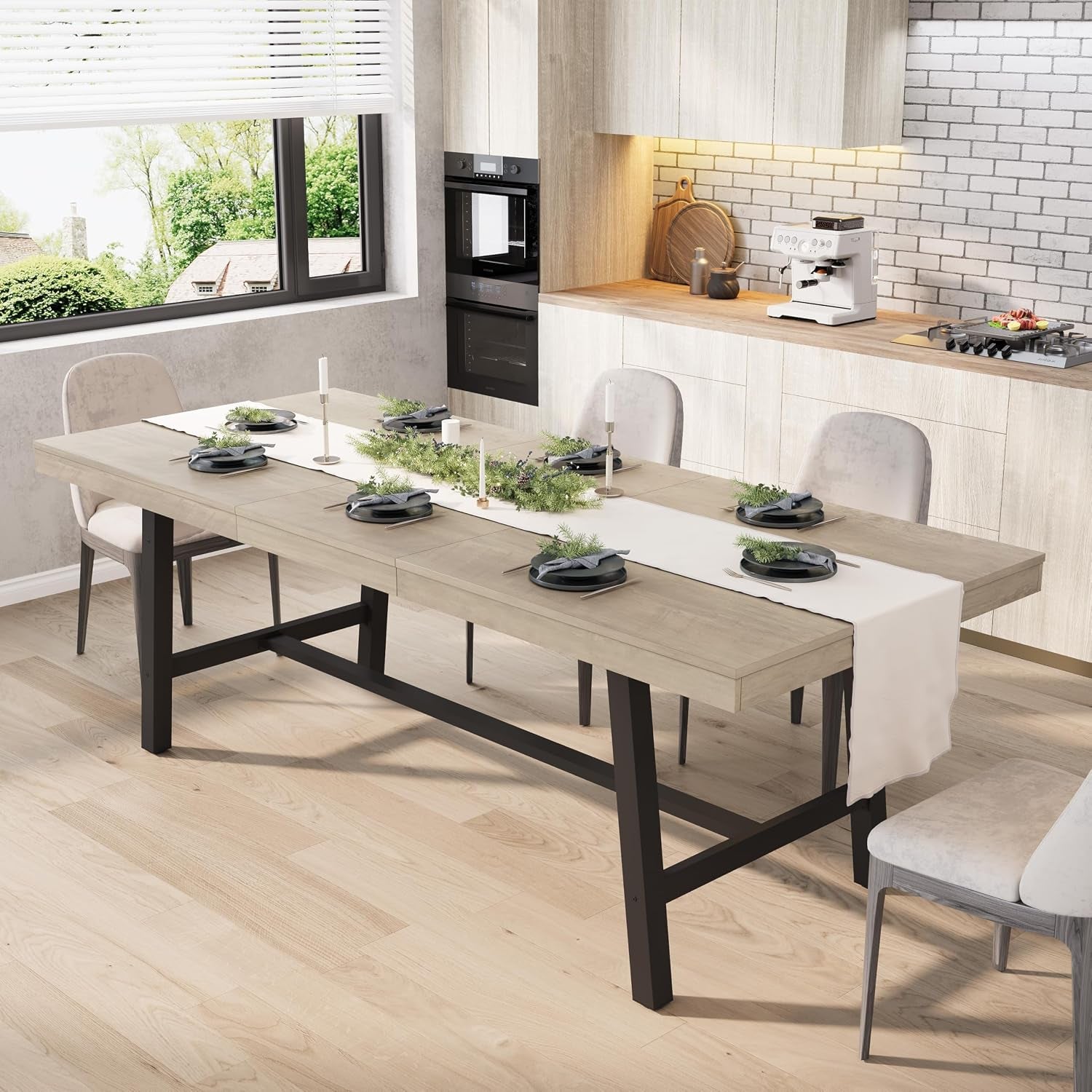 Long light-gray rectangular dining table with black metal trestle base in a modern kitchen setting