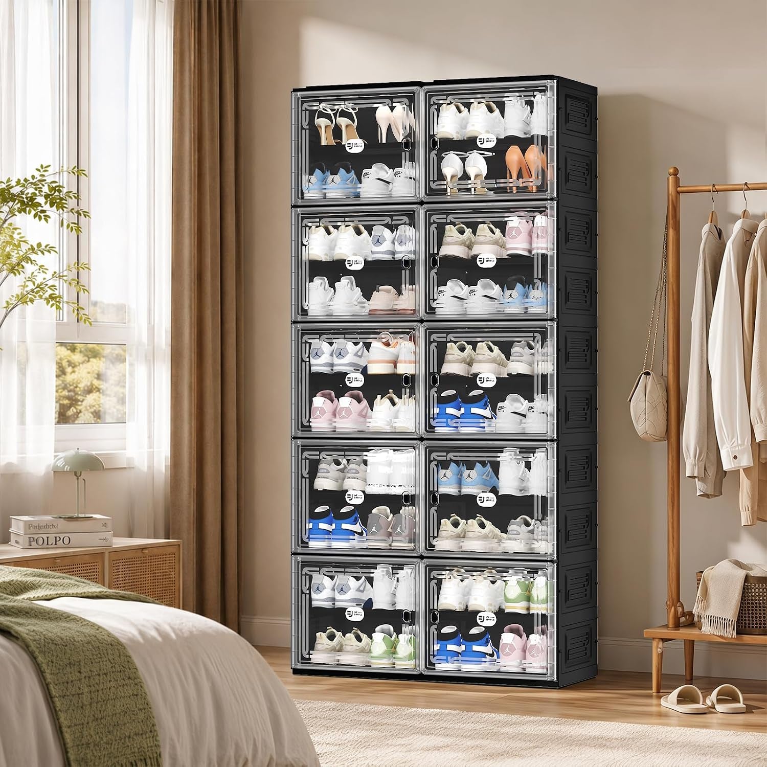 Black shoe cabinet in a bedroom setting, tall stacked 10-tier unit beside a window and clothing rack