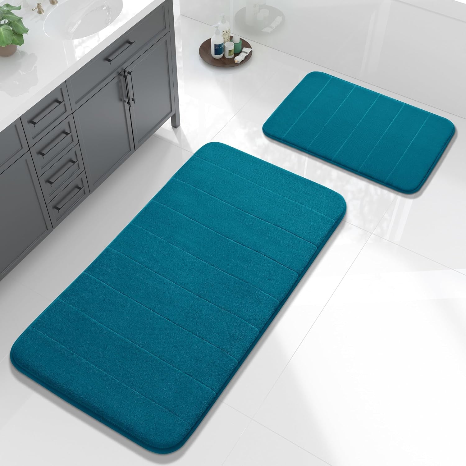 Aerial view of a bathroom with teal rectangular memory-foam mats placed near a sink and floor