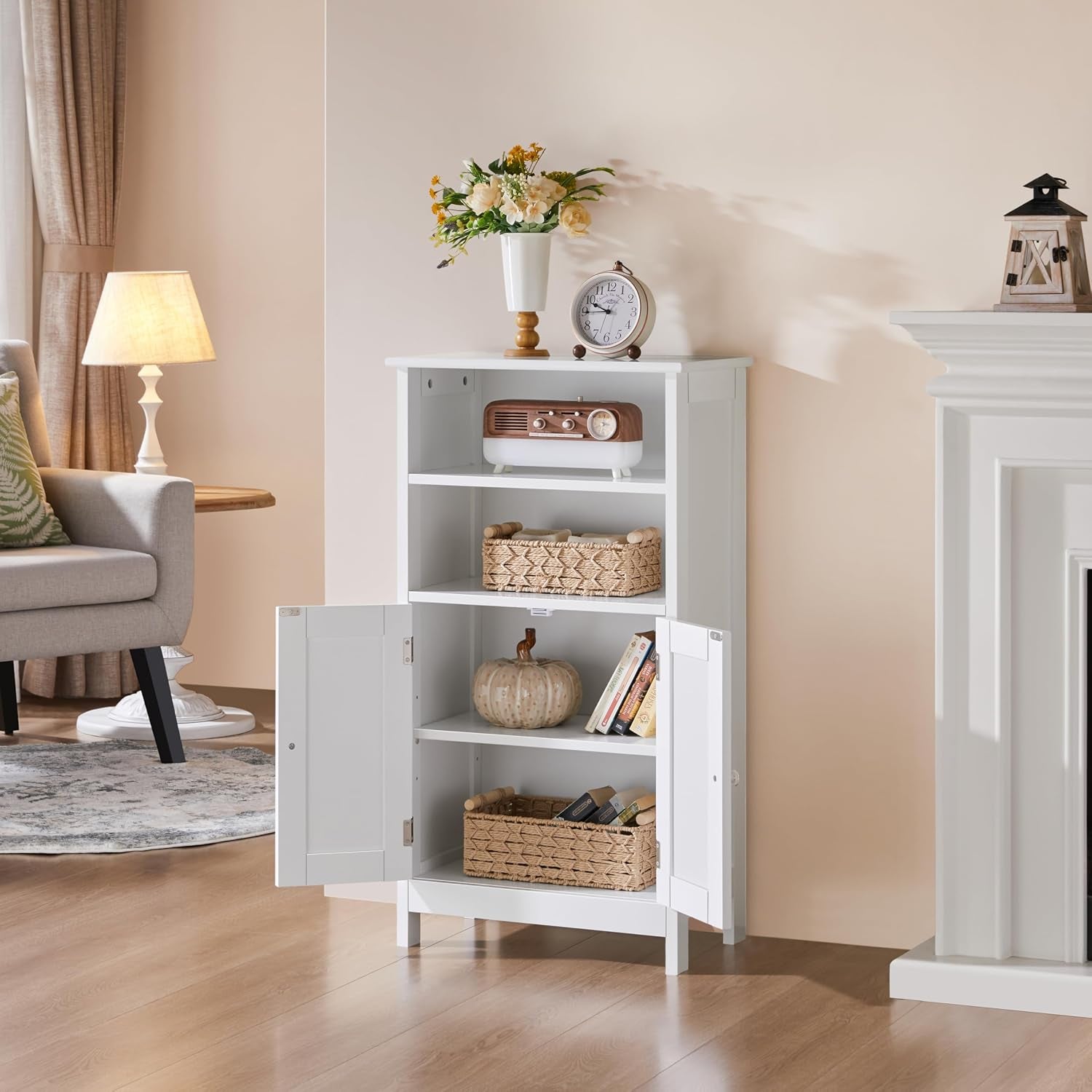 White freestanding cabinet placed in a living-room style setting with open lower doors and decorative items on shelves