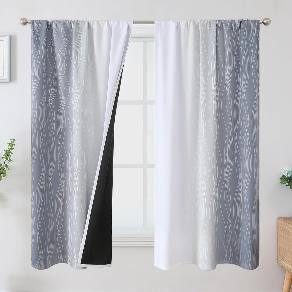 Gray ombre curtains with white inner panels and a peek of black blackout lining at the center opening.