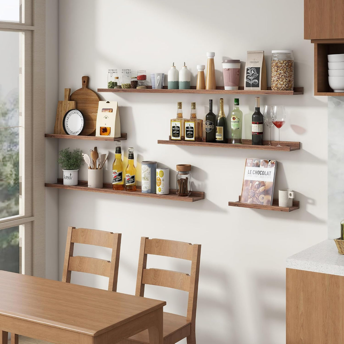 Multiple floating shelves in a dining/kitchen area displaying bottles, jars and utensils above a wooden table.