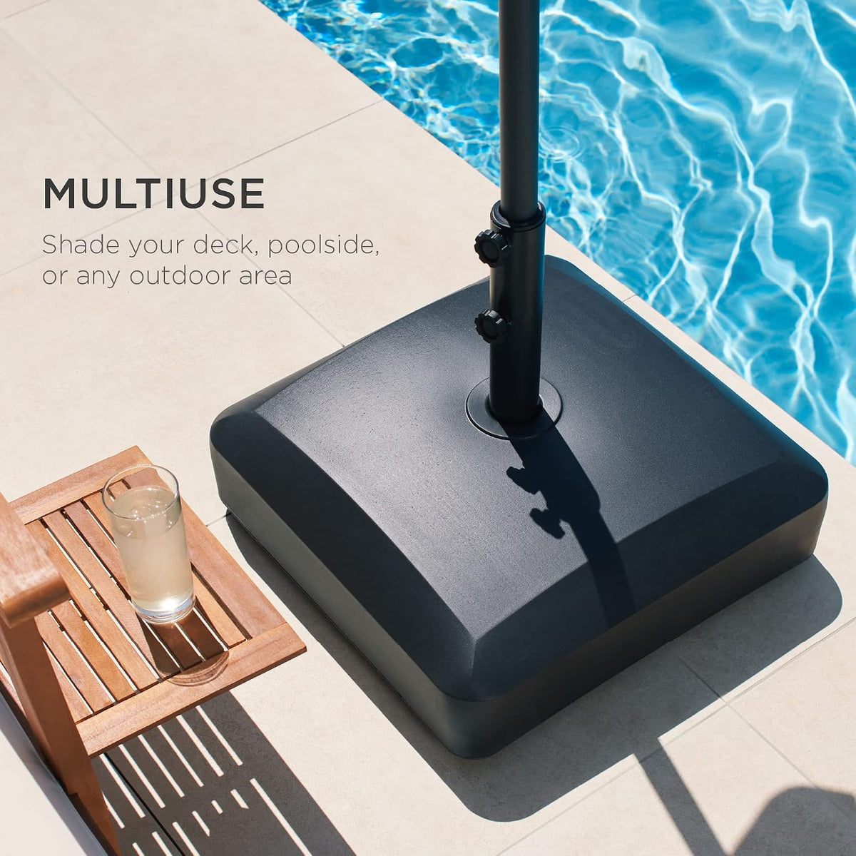 Black square umbrella base beside a pool on a tiled deck, close overhead angle showing placement