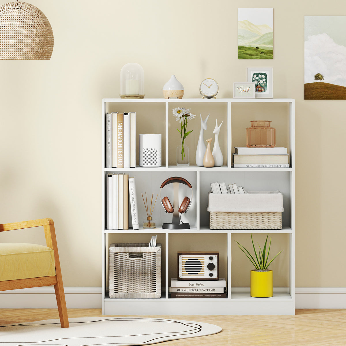 White cube bookcase styled with books, baskets, decor, and a plant in a bright living room.