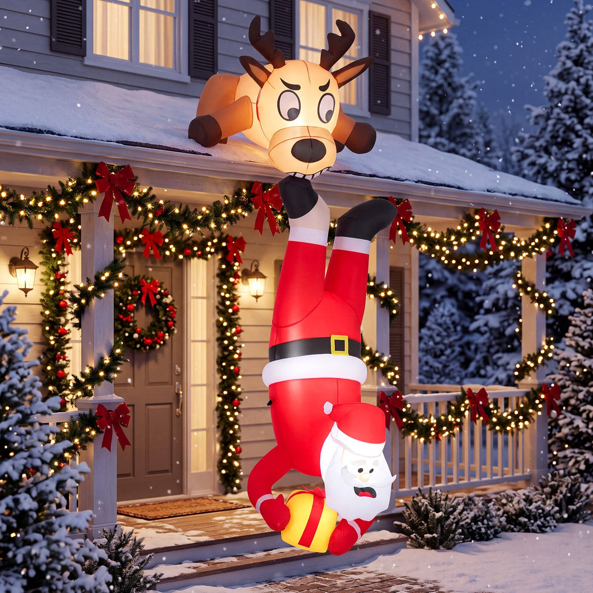 Inflatable Santa hangs upside down from a reindeer above a snow-covered, Christmas-lit porch.